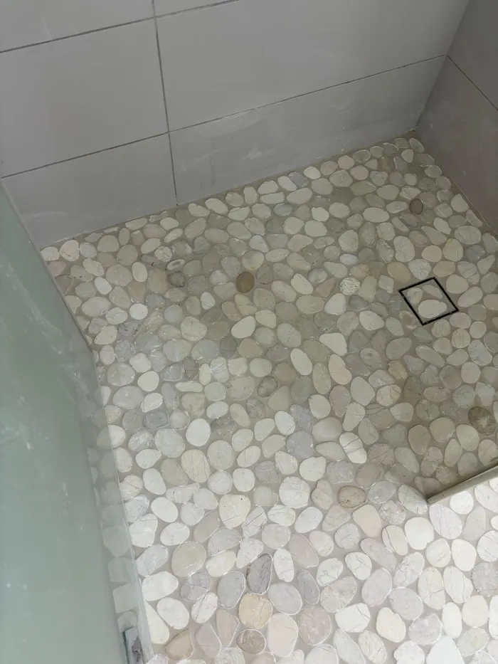 מקלחת עם ריצוף חלוקי נחל אחרי איטום
